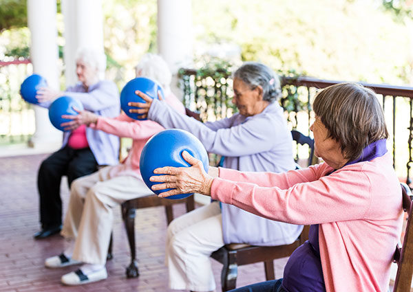 Photo of senior women stretching while holding an exercise ball