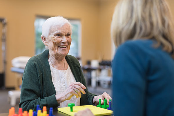 An occupational therapist works with a senior Caucasian woman 